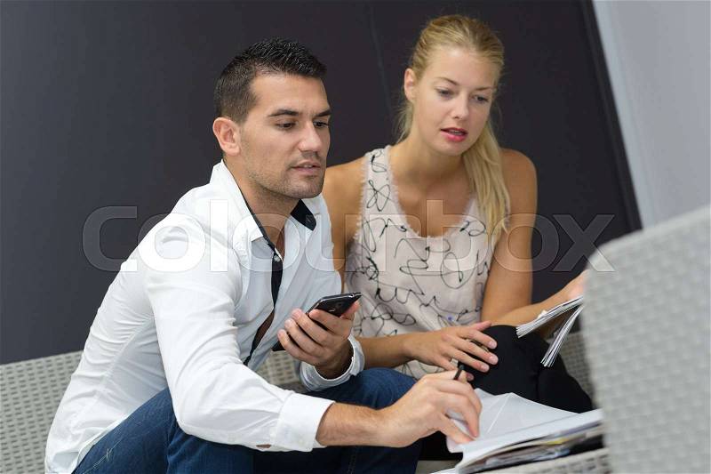 Male and female business partners working together, stock photo