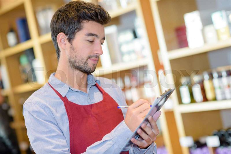 Sales assistant doing inventory count at store, stock photo