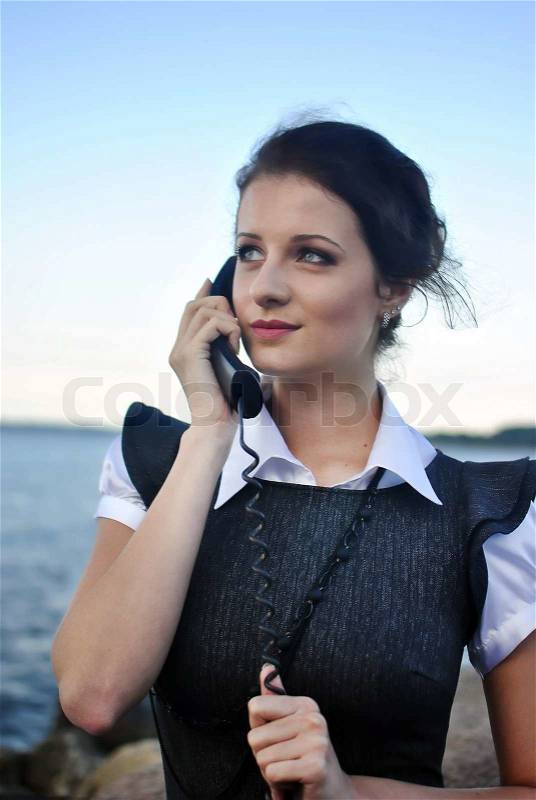 Girl with a telephone receiver in hand, space for text, stock photo