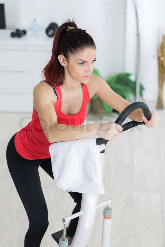 Fit blonde using the step machine at the gym, stock photo