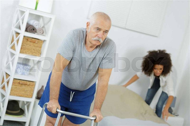 Old senior man with walker in a nursing home, stock photo