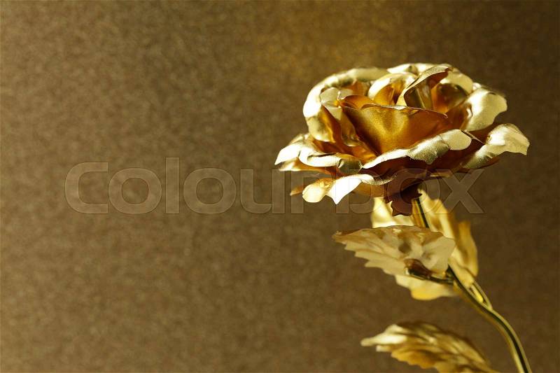 Golden flower (rose) on a sparkling gold background, stock photo