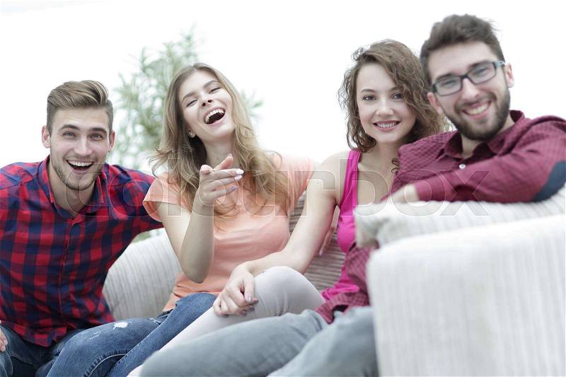 Group of happy young people sitting on the couch in the living room, stock photo