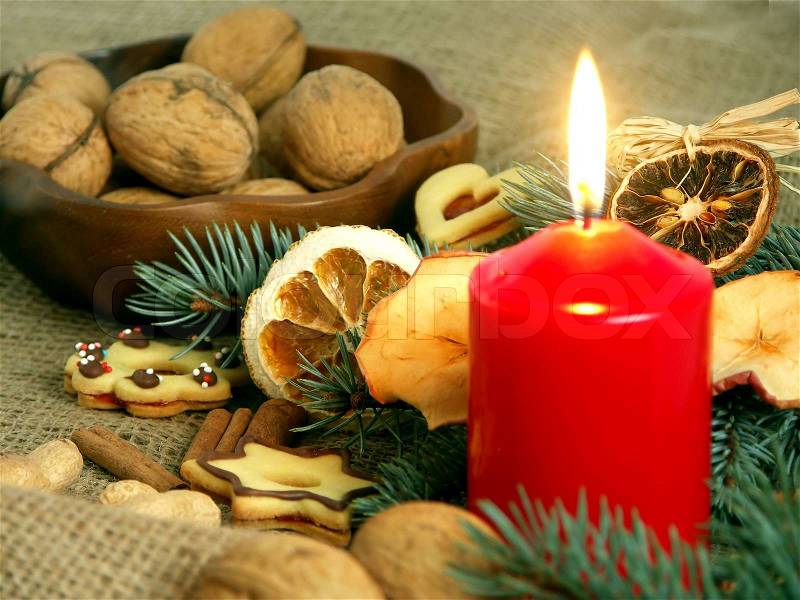 Christmas still life in red candle and dry fruit, stock photo