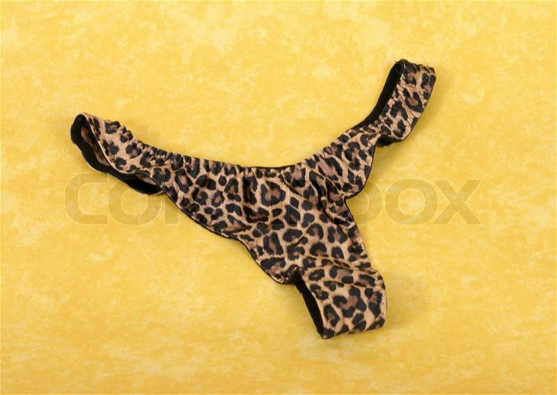 Female animal leopard print underpants g stricg on a yellow mottled background, stock photo