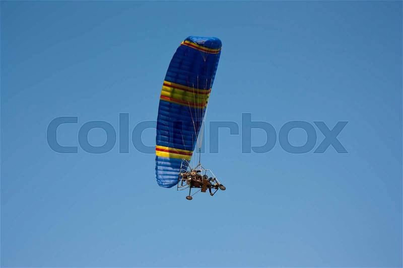 Paraglider with a motor in blue sky, stock photo