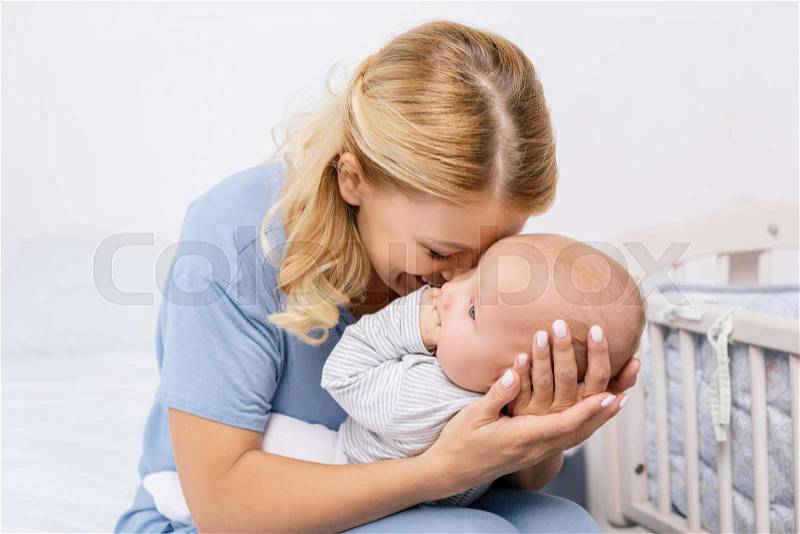 Portrait of sensual mother holding baby son, stock photo
