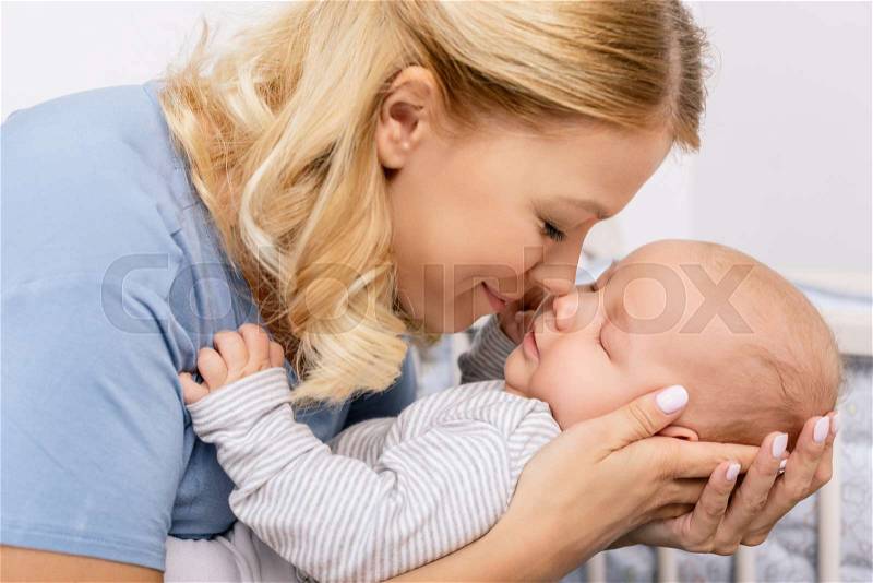 Portrait of sensual mother holding baby son, stock photo