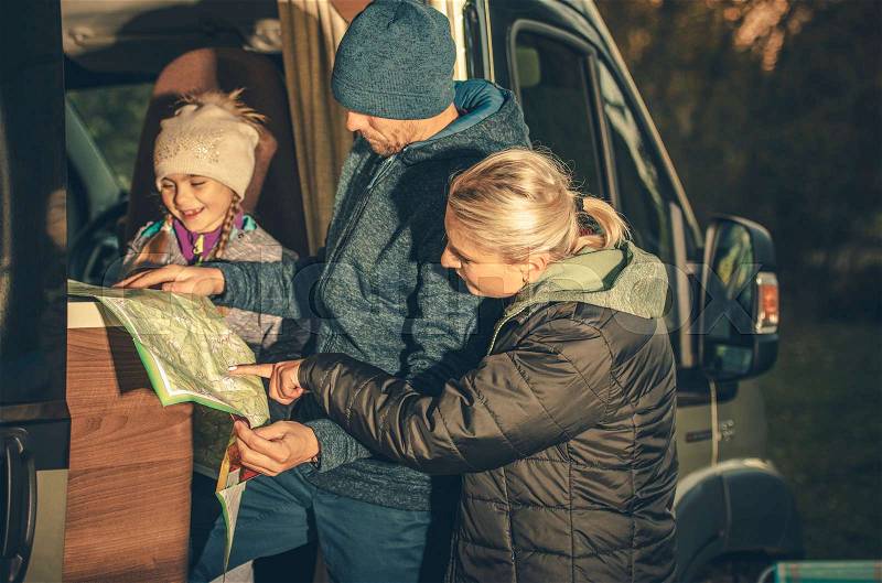 Family Camper Trip Planning. Young Caucasian Family Taking Look on the Map in the RV Motorhome Side Doors, stock photo