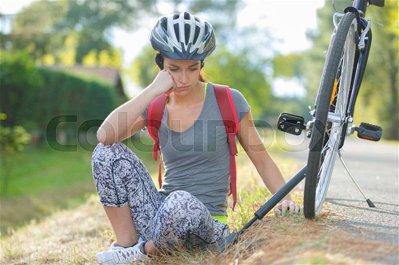 Young female broke down her bicycle and feeling bad, stock photo