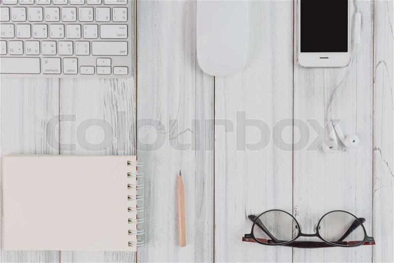 Flat lay workspace,computer,smartphone,notebook,pencil,eyeglass on white wood table,top view, stock photo