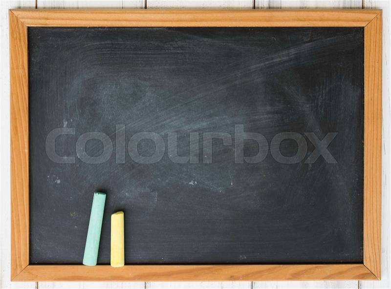 Blank black board and green,yellow chalk on grunge wooden background,top view, stock photo
