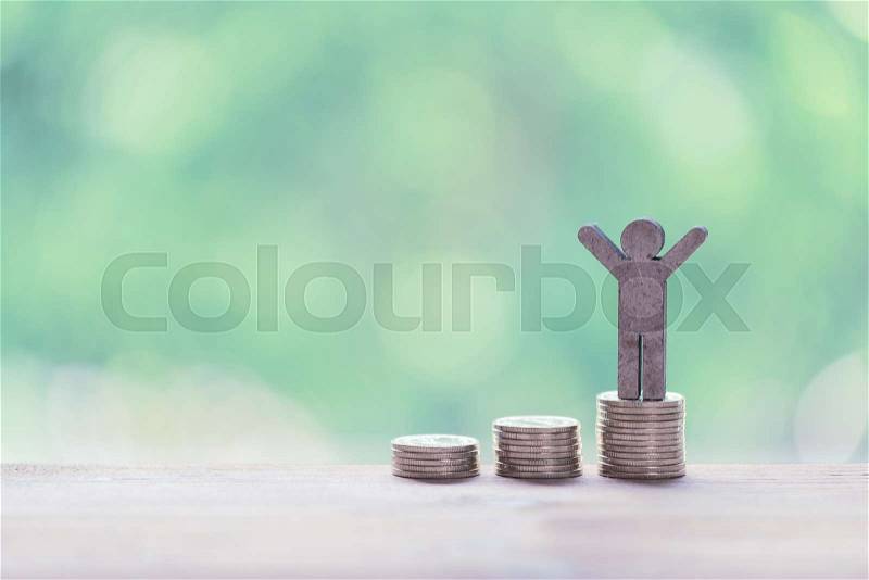 Life success concept,male miniature stand on golden stack coins over pastel background, stock photo