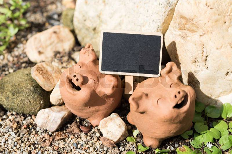 Piggy clay and black board decorative in green garden outdoor,summer time, stock photo