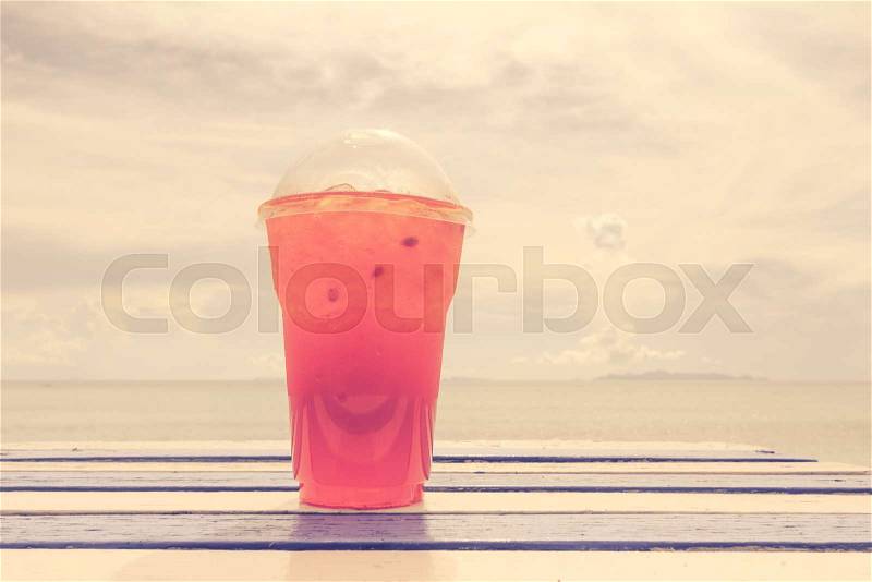 Cold drink on wooden table over summer blue sea,retro effect, stock photo