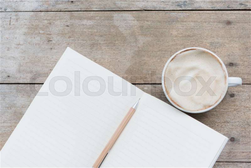 Coffee cup, notebook and pencil on grunge wood background,Top view shot, stock photo