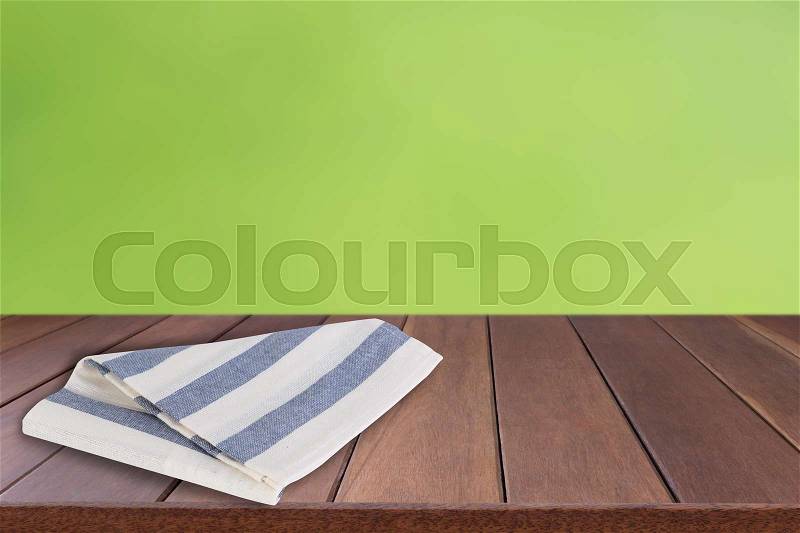 Blue and white stripes cloth on wooden top with green blurred background, stock photo