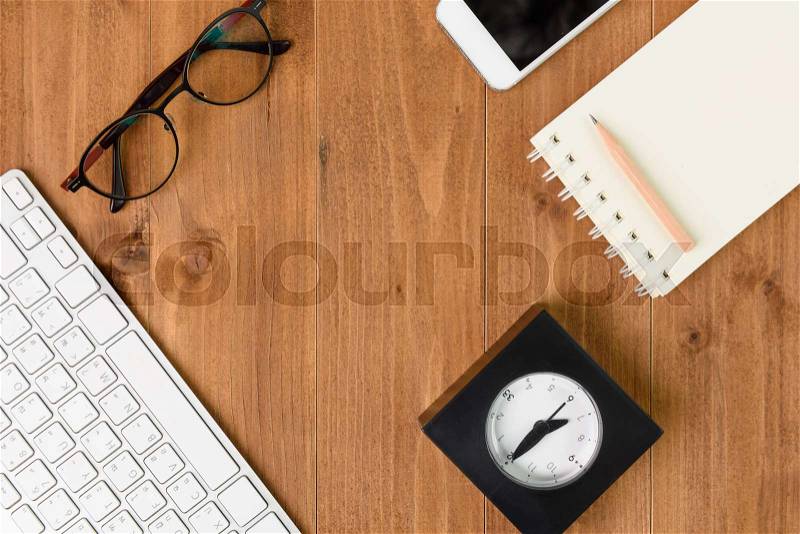 Minimal workspace,computer,smartphone,notebook,pencil,clock and eyeglasses on wood table,top view, stock photo