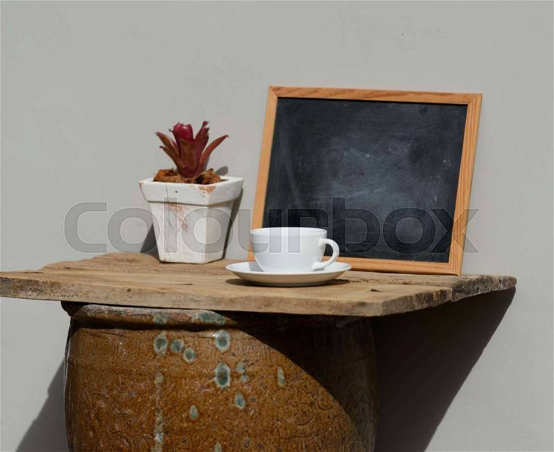 Coffee cup set over antique jar on outdoor terrace with white curtain decor, stock photo