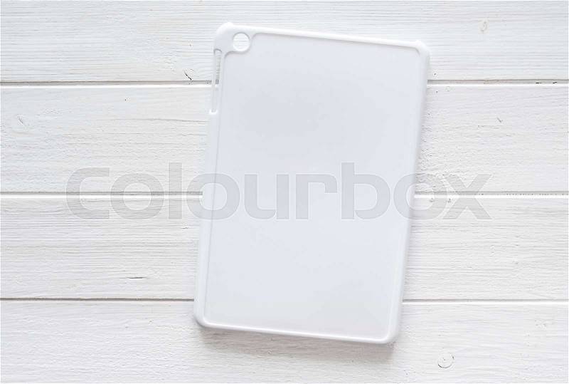 White tablet Cover for your design or text on a white wooden table, stock photo