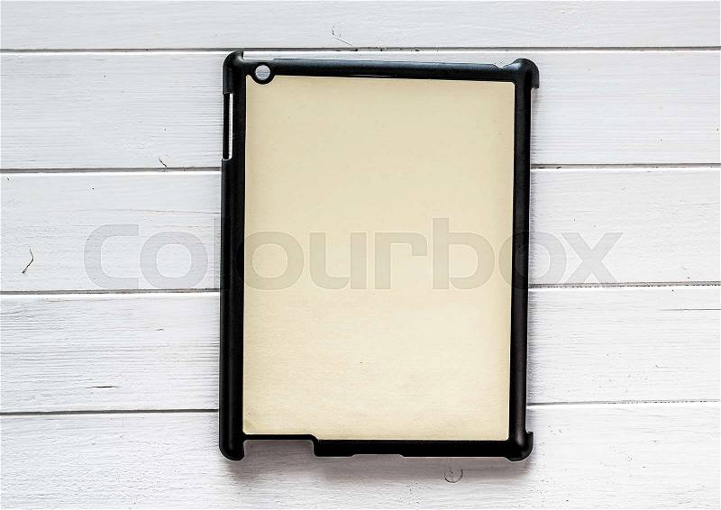 Black tablet Cover for your design or text on a white wooden table Black tablet Cover for your design or text on a white wooden table, stock photo