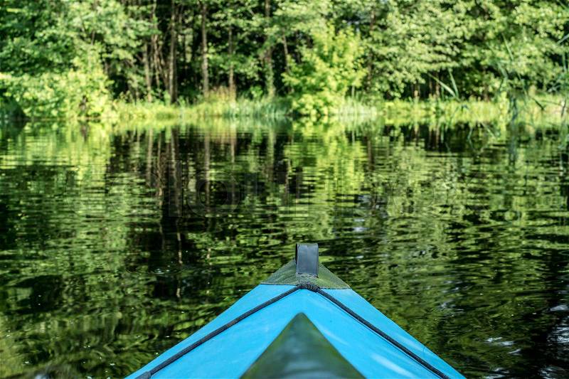 Blue canoe on the river near the forest, stock photo