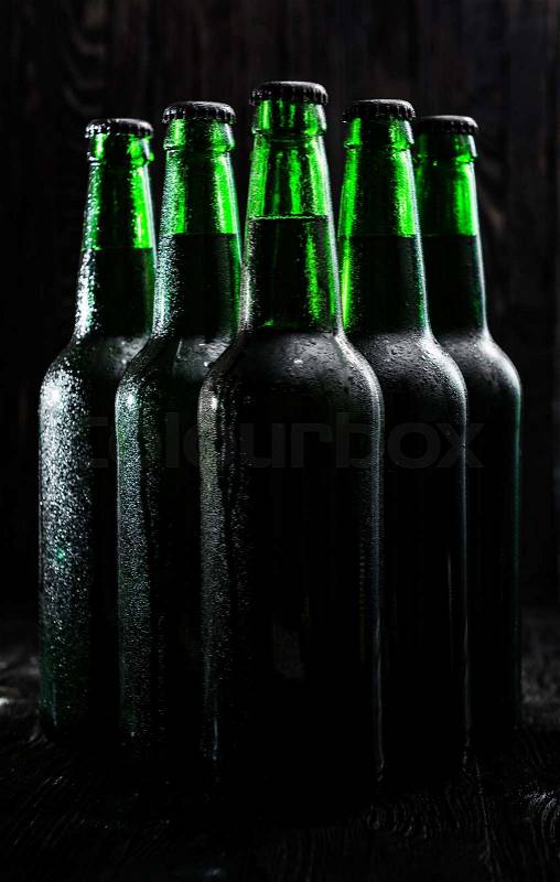 Green bottles with beer on black background, stock photo