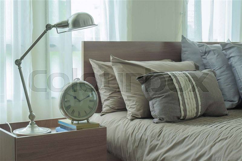 Reading lamp and clock next to japanese style bedding, stock photo