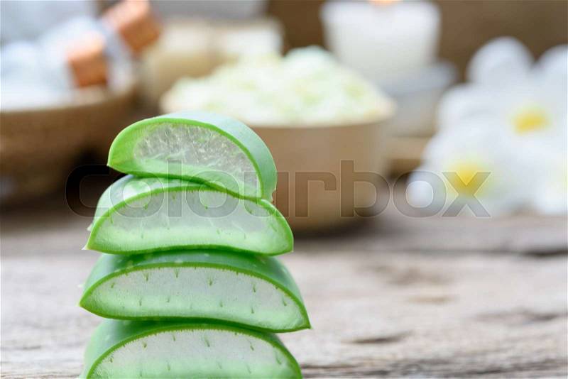 Alo Vera sliced,spa treatment and skin care products with flowers, soap,towel and herbal ball on rustic wood table,selective focus, stock photo