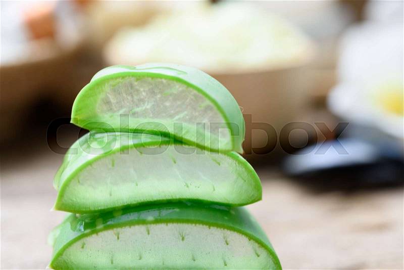 Alo Vera sliced,spa treatment and skincare products with flowers, soap,towel and herbal ball on rustic wood table,selective focus, stock photo