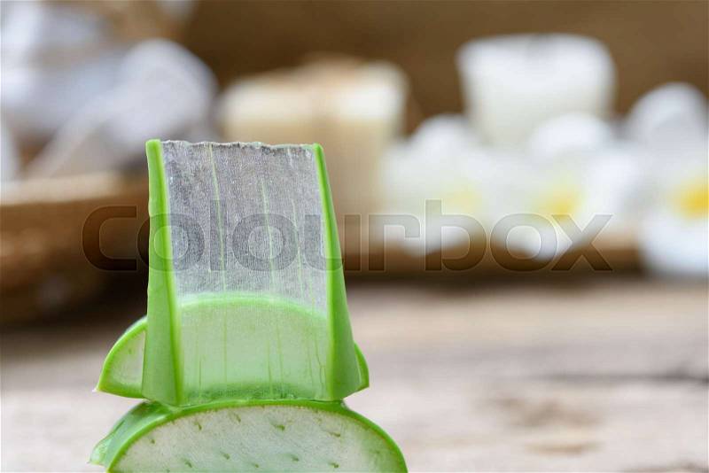 Alo Vera sliced,spa treatment and skin care products with flowers, soap,towel and herbal ball on rustic wood table,selective focus, stock photo