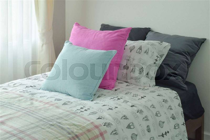 Light blue and pink pillow on single bed size, stock photo