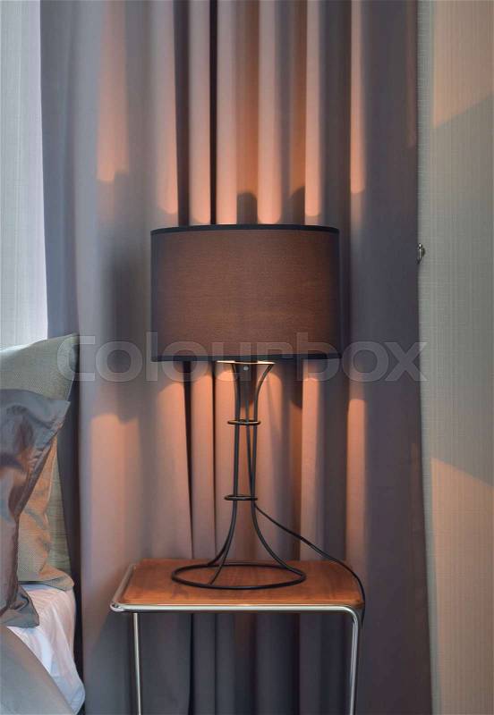 Black shade reading lamp next to bed, stock photo
