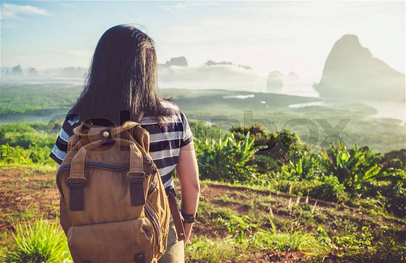 Happy young traveler woman backpacker looking backward to camera with a beautiful of nature at top of mountain view point and sea,Freedom wanderlust,Khao Samed Nang Chee Viewpoint,Phang Nga,Thailand, stock photo