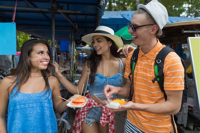 Cheerful Group Of Friends Eat Fresh Fruits Exploring Asian City And Street Cafes Tourists Happy Young People On Vacation Together, stock photo