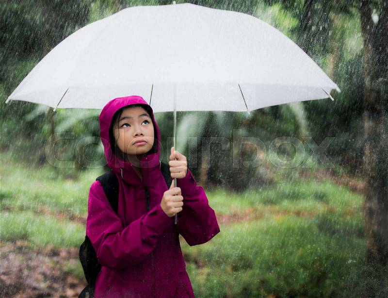 Asian girl protect water from raining by umbrella, rain, green, season and weather concept, stock photo