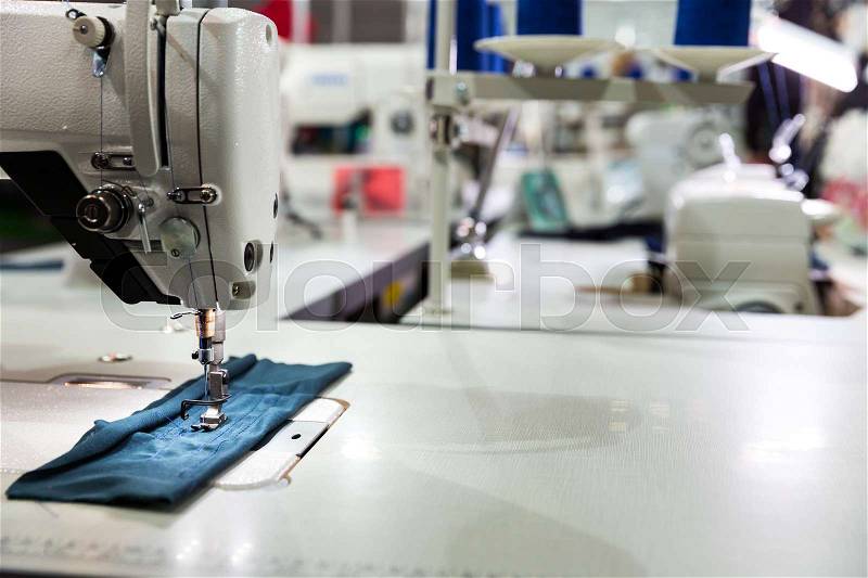 Sewing machine on textile fabric closeup, nobody. Factory production, sew manufacturing, overlock, stock photo