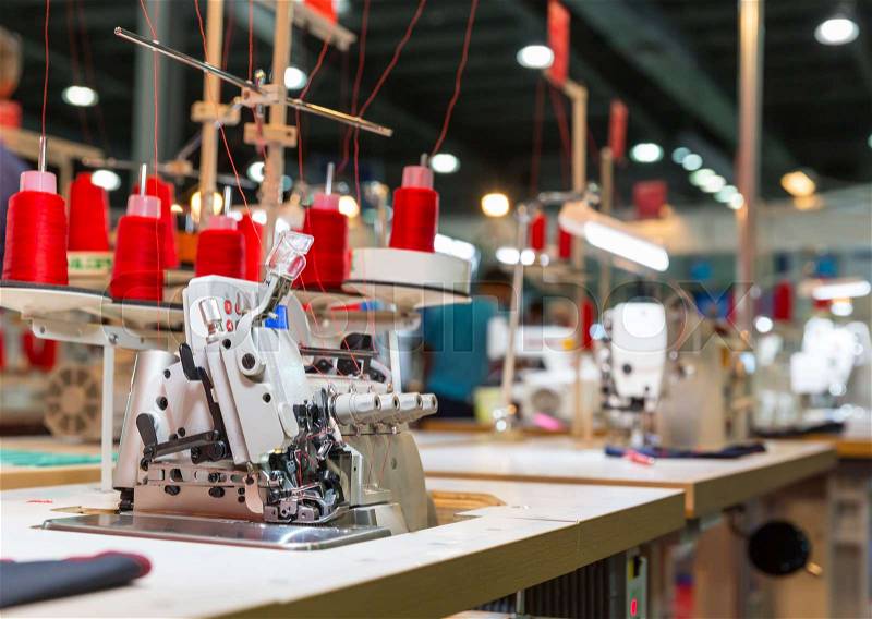 Overlock machine on sewing factory, nobody. Clothing sew. Textile fabric. Cloth manufacturing, needlework technology, stock photo