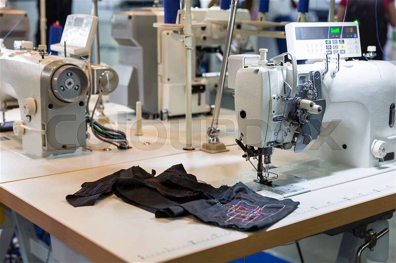 Sewing machine and cloth in cutting shop, nobody, clothing factory. Fabric production, sew manufacturing, needlework technology, stock photo