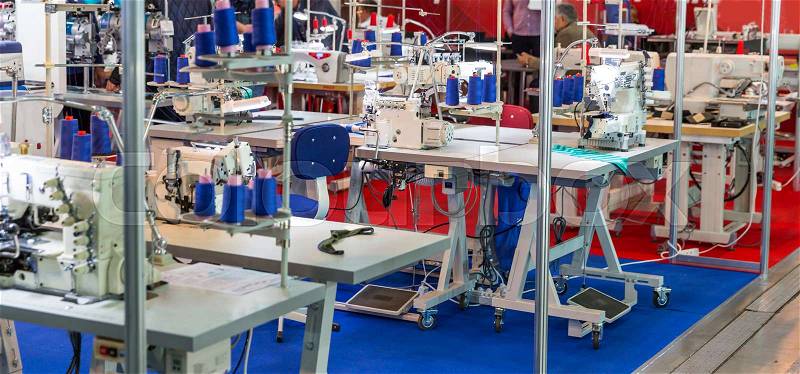 Sewing factory, nobody, overlock, stitching machines. Clothing sew Textile fabric and cloth manufacturing, stock photo