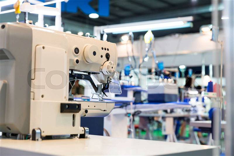 Sewing machine and cloth in cutting shop, nobody, clothing factory. Fabric production, sew manufacturing, needlework technology, stock photo