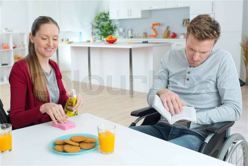 Young couple with disabled boyfriend having breakfast together, stock photo