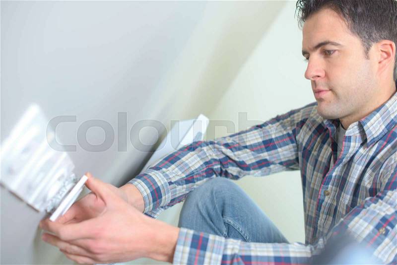 Electrician installing socket in new house, stock photo