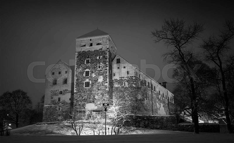 Black and white photo of Turku Castle at night, it is a medieval building in the city of Turku in Finland. It was founded in the late 13th century and stands on the banks of the Aura River, stock photo