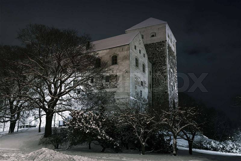 Turku Castle at dark night, it is a medieval building in the city of Turku in Finland. It was founded in the late 13th century and stands on the banks of the Aura River, stock photo