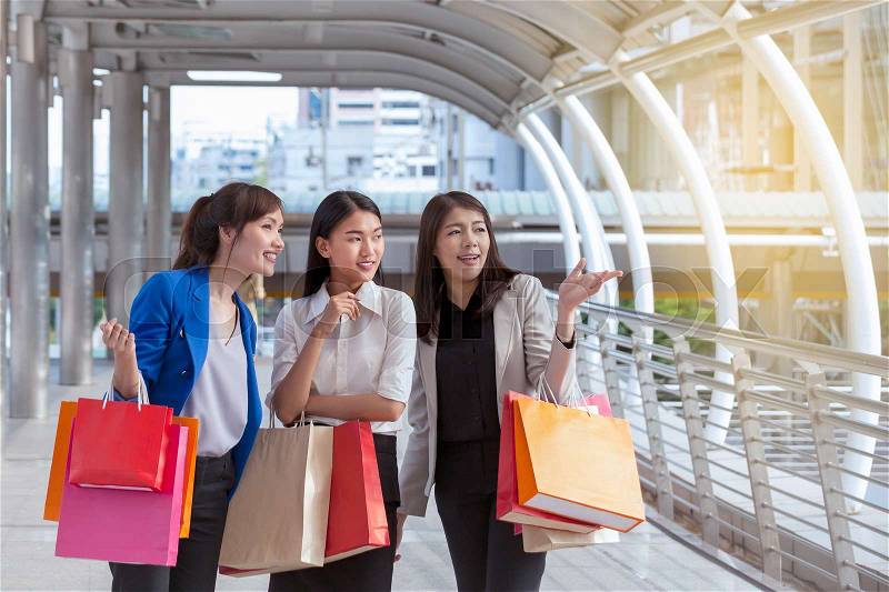 Asian woman group shopping smile and holding shopping bag with shopping mall background, consumerism, sale and people online concept, stock photo