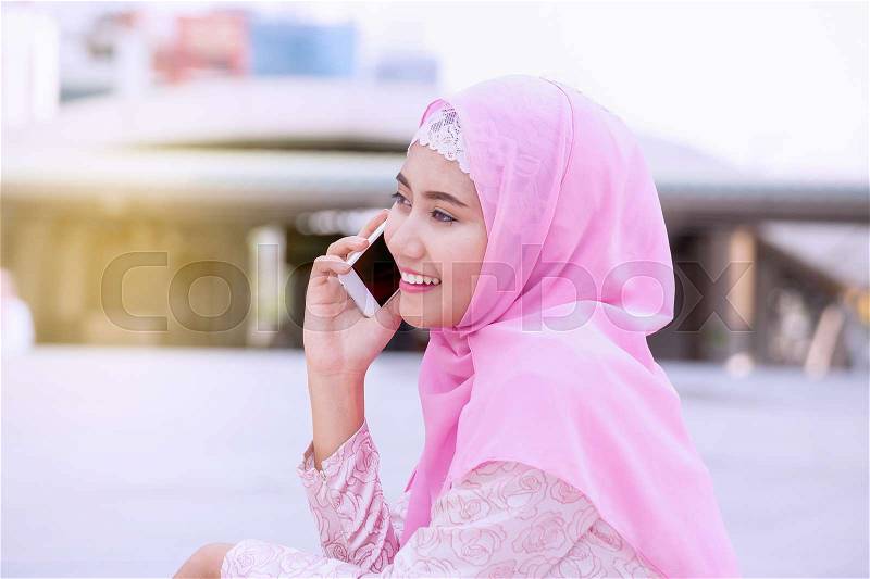 Arabian business woman smiling happy to use cell phone and modern business city background, stock photo