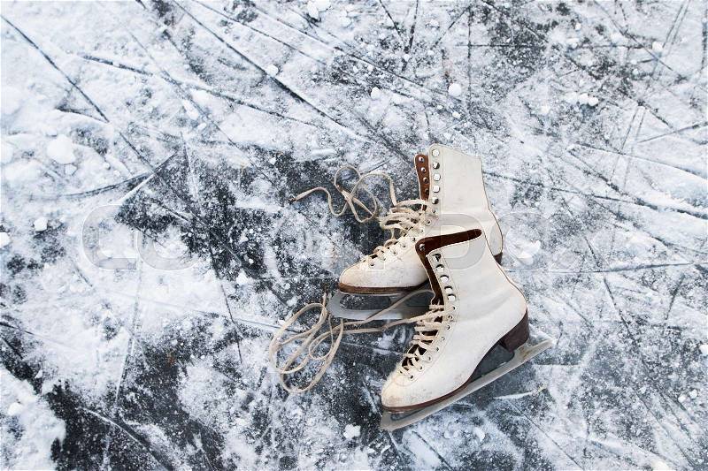 Old womans ice skates lying on the ice. Close up, stock photo