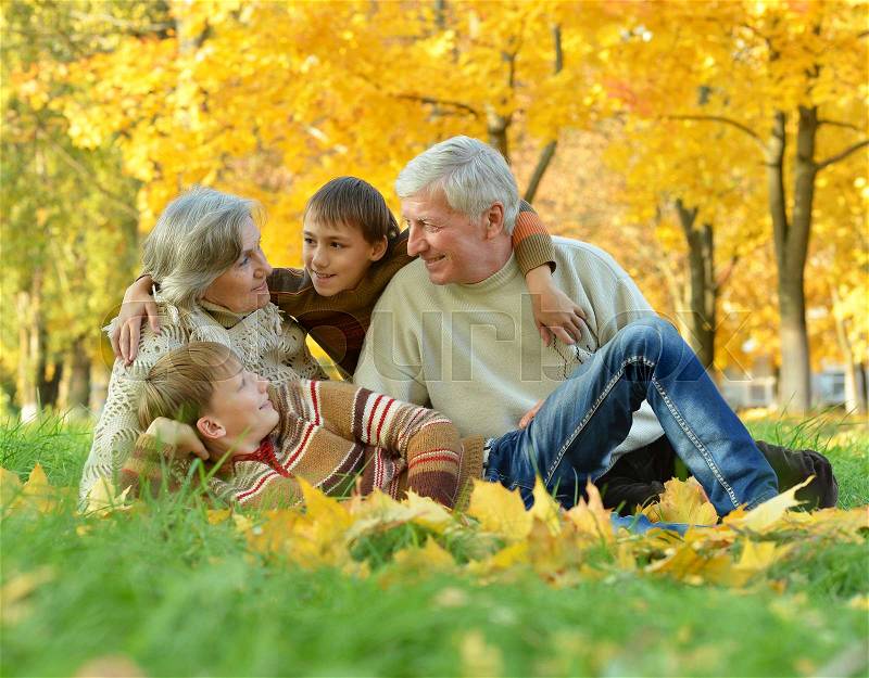 Grandparents and grandchildren together in autumn park, stock photo