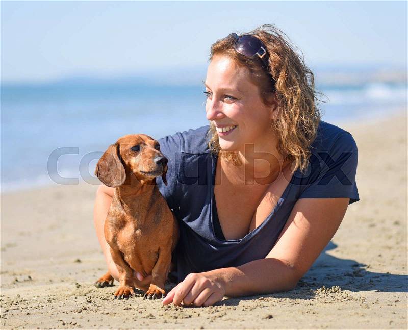 Dog and woman on the beach in september, stock photo